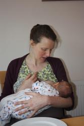 Image of a baby being breastfed by a dark-haired woman