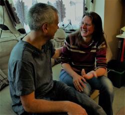 Image of two people sitting and smiling together